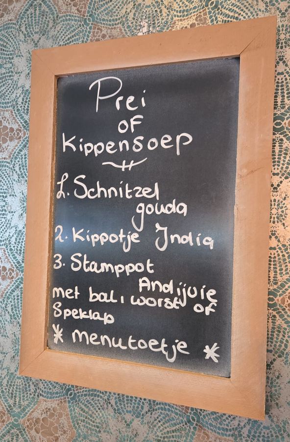 Krijtbord met de dagschotels: prei- of kippensoep, schnitzel gouda, kippetje India en stamppot andijvie met bal, worst of speklap, en een menutoetje